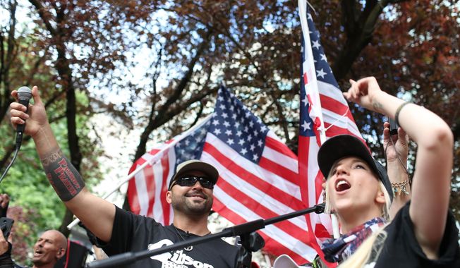 In this June 30, 2018, file photo, Joey Gibson, left, leader of Patriot Prayer, heads the group&#x27;s rally in Portland, Ore. Portland is bracing for what could be another round of violent clashes Saturday, Aug. 4, 2018, between a right-wing group holding a rally here and self-described anti-fascist counter-protesters who have pledged to keep Patriot Prayer and other affiliated groups out of this ultra-liberal city. (Mark Graves/The Oregonian via AP, file)