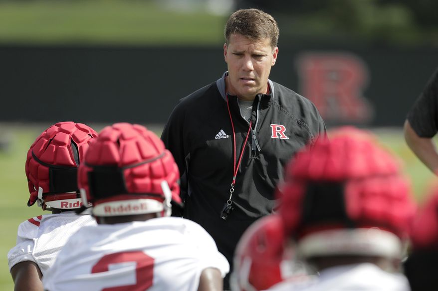 Rutgers head coach Chris Ash, center, talks to running backs as they stretch during NCAA college football training camp, Friday, Aug. 3, 2018, in Piscataway, N.J. (AP Photo/Julio Cortez)