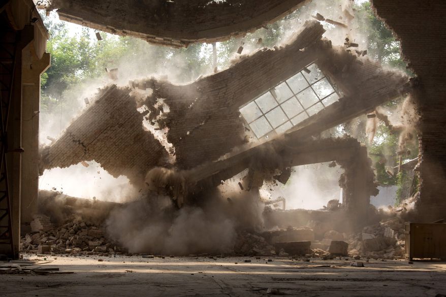 Walls of Chinese artist Ai Weiwei's studio collapse during demolition in Beijing Saturday, Aug. 4, 2018. The frequent government critic says on his Instagram account the demolition began Friday without prior notice and posted videos of an excavator smashing the windows of his "Zuoyou" studio. (AP Photo/Ng Han Guan)