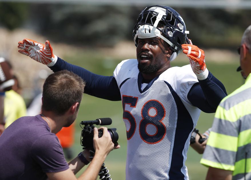 Denver Broncos linebacker Von Miller leads fans in singing birthday wishes to a fan as Miller works the rope line after drills at the team's headquarters during an NFL football training camp Saturday, Aug. 4, 2018, in Englewood, Colo. (AP Photo/David Zalubowski)