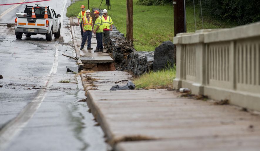 Workers from the City of Lynchburg and Wiley Wilson inspect College Lake Dam on Friday, Aug. 3, 2018 in Lynchburg, Va. Around 130 residents downstream of College Lake were evacuated the night before after a deluge on rain hit the area causing a fear of the dam failing. (AP Photo/Jill Nance)