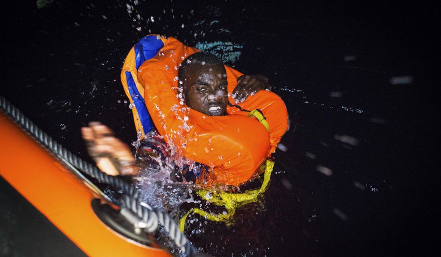 A migrant swims frantically towards a rescue ship off the coast of Libya in the early hours of Thursday night, Aug. 2, 2018. Rescuers from the Spanish non -profit Open Arms saved 87 migrants off the coast of Libya in a dramatic nighttime operation. The group included eight minors. (AP Photo/Valerio Nicolosi)