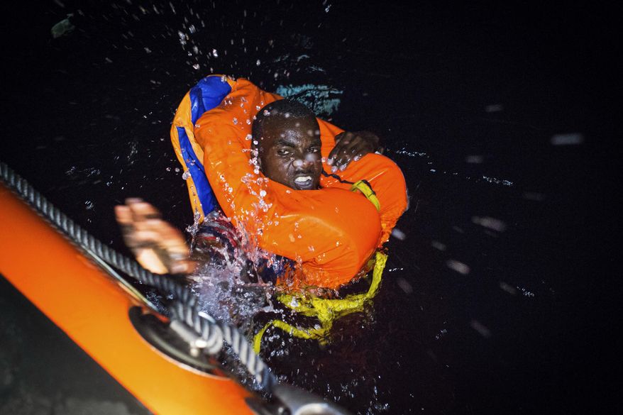 A migrant swims frantically towards a rescue ship off the coast of Libya in the early hours of Thursday night, Aug. 2, 2018. Rescuers from the Spanish non -profit Open Arms saved 87 migrants off the coast of Libya in a dramatic nighttime operation. The group included eight minors. (AP Photo/Valerio Nicolosi)