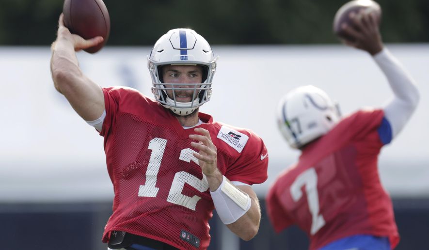 Indianapolis Colts quarterbacks Andrew Luck (12) and Jacoby Brissett throw during practice at the NFL team's football training camp in Westfield, Ind., Sunday, Aug. 5, 2018. (AP Photo/Michael Conroy)