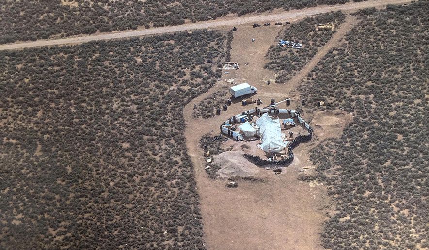 This Friday, Aug. 3, 2018, aerial photo released by Taos County Sheriff's Office shows a rural compound during an unsuccessful search for a missing 3-year-old boy in Amalia, N.M. Law enforcement officers searching the compound for the missing child didn't locate him but found 11 other children in filthy conditions and hardly any food, a sheriff said Saturday. The children ranging in age from 1 to 15 were removed from the compound and turned over to state child-welfare workers, Taos County Sheriff Jerry Hogrefe said.in Taos, N.M. (Taos County Sheriff's Office via AP)