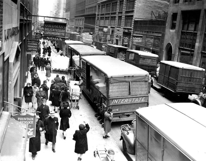 FILE - In this Nov. 29, 1943, file photo, people walk down on a street in New York's Garment District between Broadway and Eighth Avenue. Hundreds of thousands of garment workers once toiled in the sweaty, elbow-to-elbow workshops of midtown Manhattan before the whirring of sewing machines was mostly silenced by foreign competition. But a group of New Yorkers - manufacturers, landlords, designers, politicians - want to preserve some of the bustling sewing scene by zoning the neighborhood for at least 300,000 square feet of garment workshops now serving higher-end designers. (AP Photo/File)