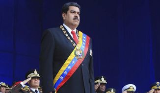 In this photo provided by the Miraflores Presidential Palace, President Nicolas Maduro stands at attention during a event marking the 81st anniversary of the National Guard, in Caracas, Venezuela, Saturday, August 4, 2019. Venezuela&#39;s government says several explosions heard at a military event were an attempted attack on President Maduro. Information Minister Jorge Rodriguez said in a live broadcast that several drone-like devices with explosives detonated near the president. He said Maduro is safe and unharmed but that seven people were injured. (Miraflores Presidential Palace via AP)