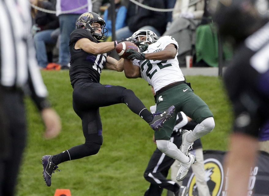 FILE - In this Saturday, Oct. 28, 2017, file photo, Northwestern wide receiver Macan Wilson, left, and Michigan State cornerback Josiah Scott battle for the ball during the first half of an NCAA college football game in Evanston, Ill. Michigan State coach Mark Dantonio announced Monday, Aug. 6, 2018, that cornerback Josiah Scott is expected to miss about two months after a non-contact injury. (AP Photo/Nam Y. Huh, File)