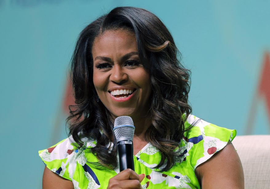 FILE - In this June 22, 2018 file photo, former first lady Michelle Obama speaks at the American Library Association annual conference in New Orleans. Michelle Obama is marking the 53rd anniversary of the Voting Rights Act by urging Americans to participate in a week of action to get people signed up to vote. The former first lady announced Monday that the When We All Vote Week of Action will be held Sept. 22-29. (AP Photo/Gerald Herbert)
