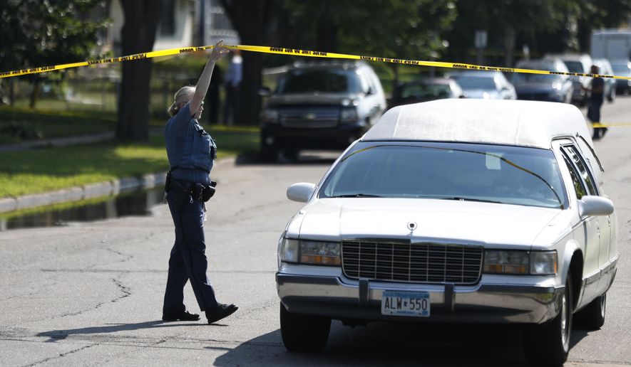 St. Paul Police officer Colleen Lesedil lifs crime scene tape, as the Ramsey county medical examiner leaves the scene with the body of a person that was shot and killed by St. Paul police in the 900 block of St. Anthony Avenue Sunday, Aug. 5, 2018, in St. Paul, Minn. Police say officers shot an armed man while responding to a 911 call early Sunday about shots fired at a home. (Jerry Holt/Star Tribune via AP)