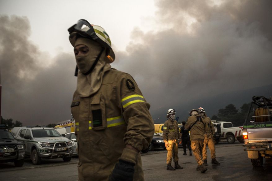 A firefighter group set before heading towards the fire at the village of Monchique, in southern Portugal's Algarve region, Sunday, Aug. 5 2018. Over 700 firefighters were still battling a forest fire near the Portuguese town of Monchique in the southern Algarve region, a popular tourist destination. (AP Photo/Javier Fergo)