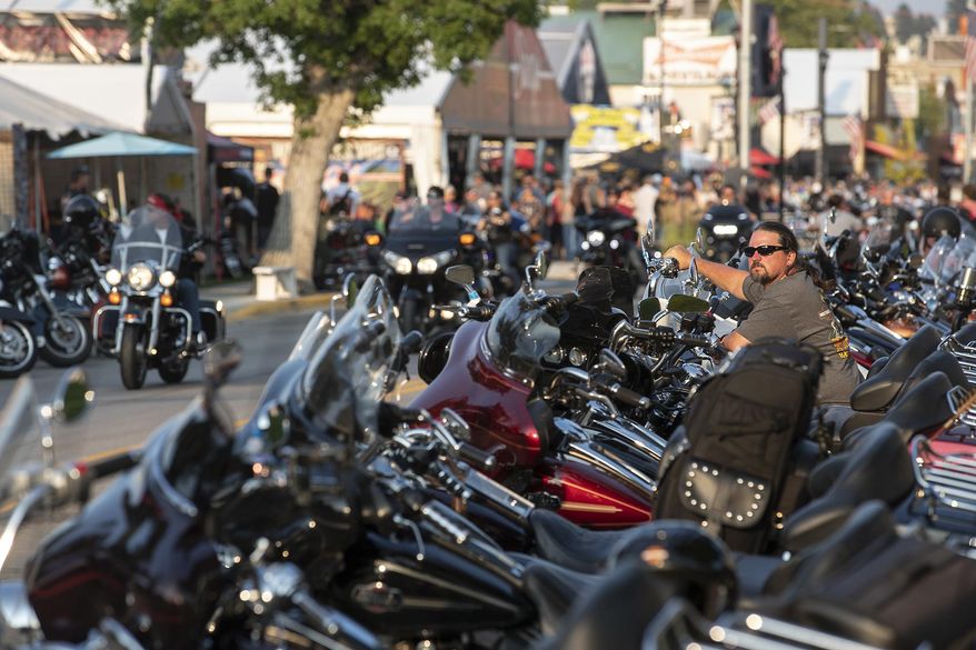 In this Saturday, Aug. 4, 2018, photo, Rob Gregory, of Knoxville, Tenn., sits on his motorcycle parked along Main Street in Sturgis, S.D., during the 78th annual Sturgis Motorcycle Rally. (Ryan Hermens/Rapid City Journal via AP)