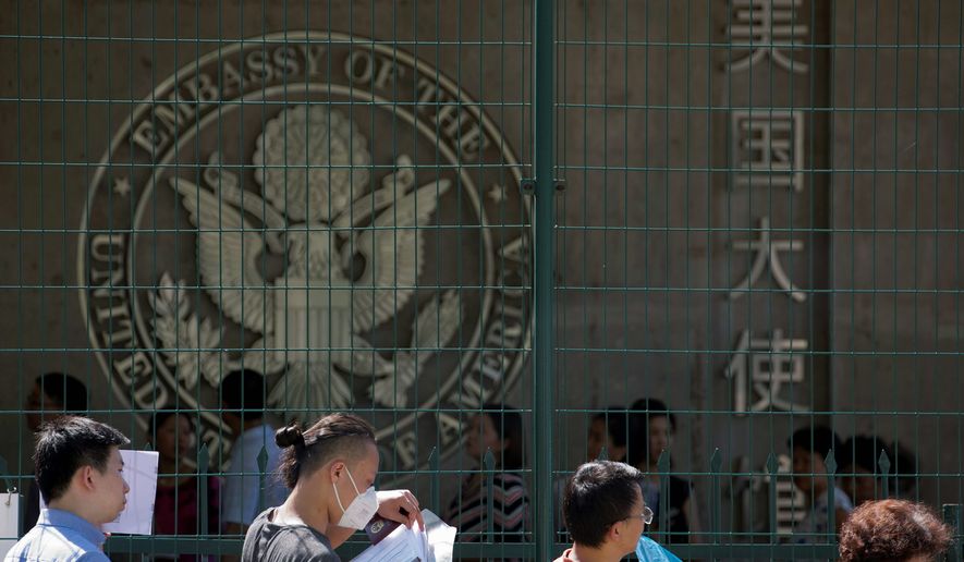 In this July 26, 2018, photo, visa applicants wait to enter the U.S. Embassy in Beijing, China. Data analysis by the Center for Migration Studies shows that about 5.5 million illegal immigrants since the year 2000 came to the U.S. legally but overstayed their visas. (AP Photo/Ng Han Guan) **FILE**