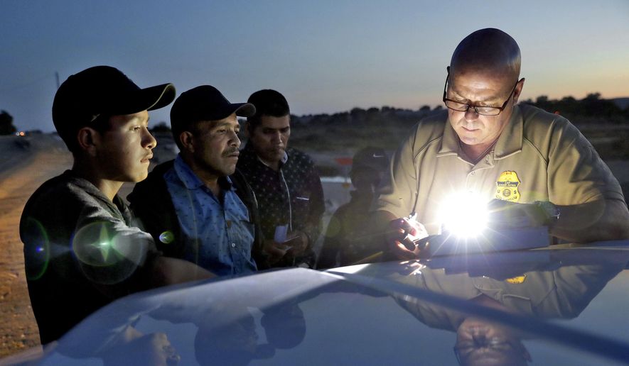A U.S. Customs and Border Patrol agent gathers information on four Guatemalan nationals, including two men and a pair of 12 and 13-year-old boys, Wednesday, July 18, 2018, in Yuma, Ariz. Thousands of families and unaccompanied children are continuing to cross the U.S. border in Arizona and California even after learning of the government&#39;s family separation policy upon apprehension. (AP Photo/Matt York)