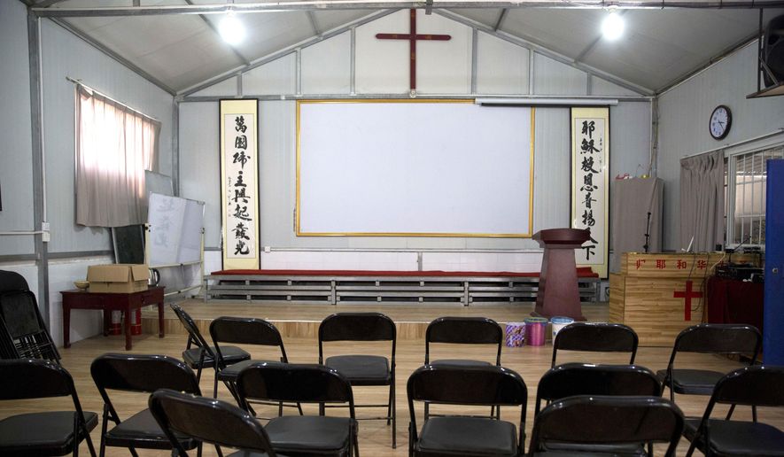 In this photo taken Monday, June 4, 2018, Chinese calligraphy which reads &quot;All nations belong to the Lord arising to shine&quot; at left and &quot;Jesus&#x27;s salvation spreads to the whole world&quot; at right are displayed below a crucifix in a house church shut down by authorities near the city of Nanyang in central China&#x27;s Henan province. Under President Xi Jinping, China&#x27;s most powerful leader since Mao Zedong, believers are seeing their freedoms shrink dramatically even as the country undergoes a religious revival. Experts and activists say that as he consolidates his power, Xi is waging the most severe systematic suppression of Christianity in the country since religious freedom was written into the Chinese constitution in 1982. (AP Photo/Ng Han Guan)