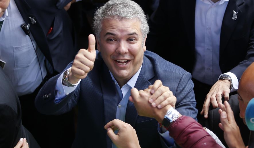 In this June 17, 2018, file photo, Ivan Duque, candidate of the Democratic Center party, gives a thumbs-up to supporters after voting in the presidential runoff election in Bogota, Colombia. Duque will be sworn in as the new leader of Colombia on Tuesday, Aug. 7, 2018, tasked with guiding the implementation of a historic peace accord with leftist rebels that remains on shaky ground. (AP Photo/Fernando Vergara, File)