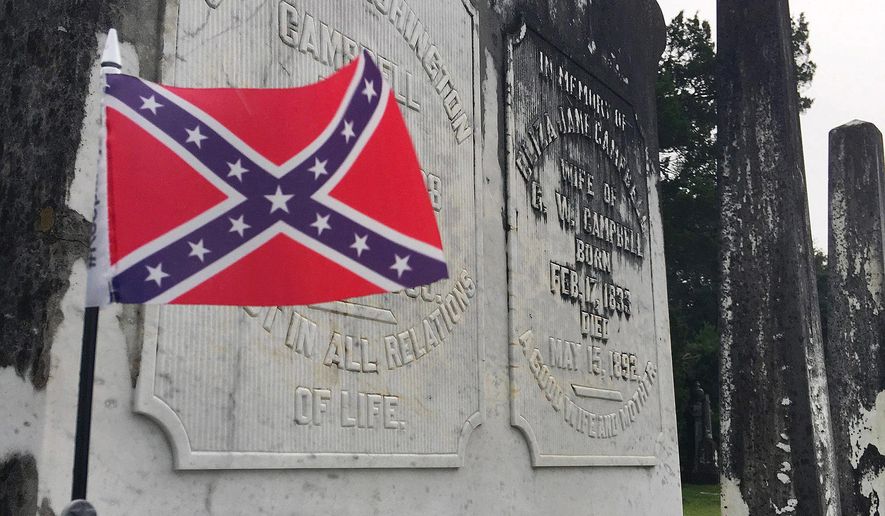 A small Confederate battle flag waves at the grave of a Confederate veteran in a cemetery in Tuskegee, Ala., on Tuesday, July 31, 2018. (AP Photo/Jay Reeves)