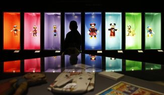 FILE- In this Nov. 16, 2017, file photo, a visitor walks past a display of Disney characters inside an exhibition entitled &amp;quot;Mexico and Walt Disney: A Magical Encounter,&amp;quot; at the Cineteca Nacional, Mexico&#39;s film archive, in Mexico City. The Walt Disney Co. reports earnings Tuesday, Aug. 7, 2018. (AP Photo/Rebecca Blackwell, File)