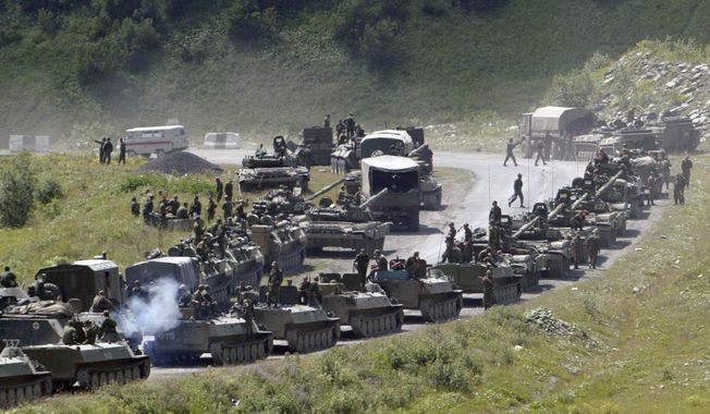 In this file photo taken on Saturday, Aug. 9, 2008, a column of Russian armored vehicles seen on their way to the South Ossetian capital Tskhinvali somewhere in the Georgian breakaway region, South Ossetia, Georgia. The Russian military quickly routed the Georgian army during the August 2008 war. Russia&#x27;s Prime Minister Dmitry Medvedev in an interview broadcast by Russian state television Tuesday Aug. 7, 2018, on the 10th anniversary of the Russia-Georgia war, issued a stern warning that incorporating Georgia into NATO could trigger a new &amp;quot;horrible&amp;quot; conflict. (AP Photo/Musa Sadulayev, File)