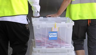 King County Election officials collect ballots from a drop box Tuesday morning, Aug. 7, 2018, in Seattle. Washington voters will decide which candidates advance to the November ballot in 10 congressional races, a U.S. Senate seat and dozens of legislative contests in the state&#x27;s primary election Tuesday. (AP Photo/Elaine Thompson)