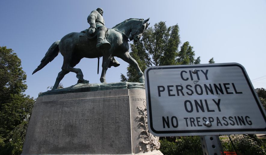 In this Monday, Aug. 6, 2018, file photo, a &quot;No Trespassing&quot; sign is displayed in front of a statue of Robert E. Lee in Charlottesville, Va., at the park that was the focus of the &quot;Unite the Right&quot; rally. Pressure to take down America’s monuments honoring slain Confederate soldiers and the generals who led them didn’t start with Charlottesville. But the deadly violence that rocked the Virginia college town a year ago gave the issue an explosive momentum. (AP Photo/Steve Helber)