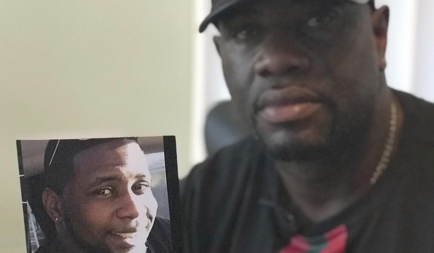 In an Aug. 7, 2018 photo, Michael McGlockton holds a photo of his son, Markeis McGlockton, in Clearwater, Fla. Markeis was shot and killed on July 19 in Clearwater, Florida during an argument over a parking spot. The shooter, Michael Drejka, said he was defending himself and is using Florida&#39;s controversial &#39;Stand Your Ground&#39; defense. (AP Photo/Tamara Lush)