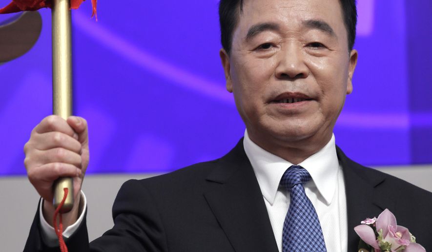 China Tower Corp. Ltd. Chairman Tong Jilu holds a drum stick to hit the gong during the listing ceremony at the Hong Kong Stock Exchange in Hong Kong Wednesday, Aug. 8, 2018. China Tower, the state-backed company that operates the world's largest network of telecoms towers, made a debut in Hong Kong Stock Exchange on Wednesday, raising US$6.9 billion. (AP Photo/Vincent Yu)