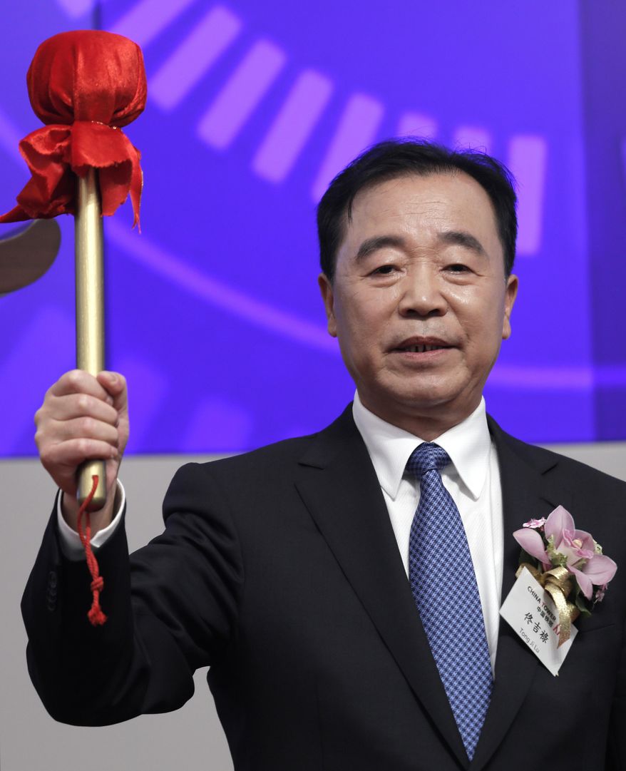 China Tower Corp. Ltd. Chairman Tong Jilu holds a drum stick to hit the gong during the listing ceremony at the Hong Kong Stock Exchange in Hong Kong Wednesday, Aug. 8, 2018. China Tower, the state-backed company that operates the world's largest network of telecoms towers, made a debut in Hong Kong Stock Exchange on Wednesday, raising US$6.9 billion. (AP Photo/Vincent Yu)