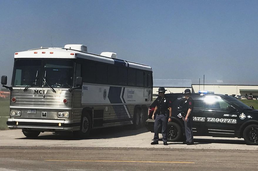 An ICE bus pulls out of a tomato plant in O'Neill, Neb., after an immigration raid at the plant Wednesday, Aug. 8, 2018. A large federal law enforcement operation conducted Wednesday targeted businesses in Nebraska and Minnesota that officials say knowingly hired - and mistreated - immigrants who are in the U.S. illegally. (Paul Hammel/Omaha World-Herald via AP)