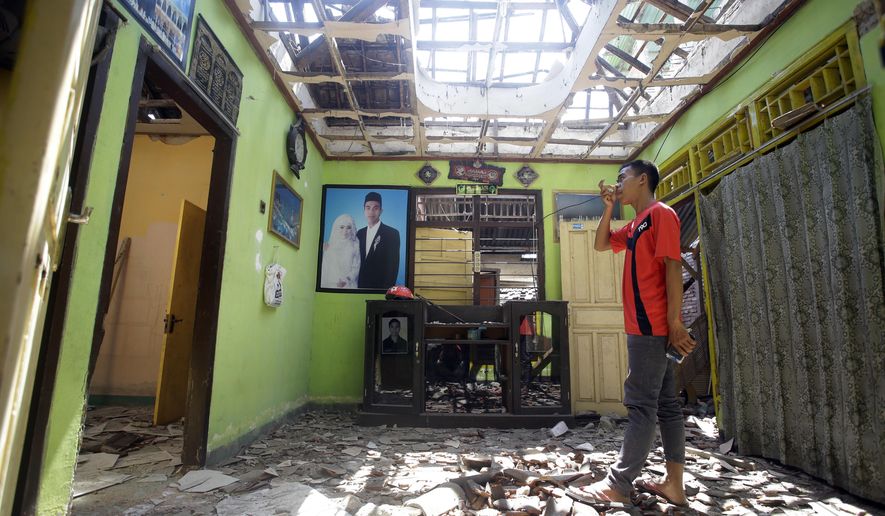 A villager visits his damaged house in the Kekait village affected by Sunday's earthquake in North Lombok, Indonesia, Wednesday, Aug. 8, 2018. Aid has begun reaching isolated areas of the Indonesian island struggling after an earthquake killed over 100 people as rescuers intensify efforts to find those buried in the rubble. (AP Photo/Firdia Lisnawati)