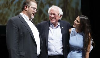 In this July 20, 2018, file photo, Democratic Kansas U.S. congressional candidate James Thompson, left, U.S Sen. Bernie Sanders, I-Vt., and Alexandria Ocasio-Cortez, a Democratic congressional candidate from New York, stand together on stage after a rally in Wichita, Kan. (Jaime Green/The Wichita Eagle via AP, File) **FILE**