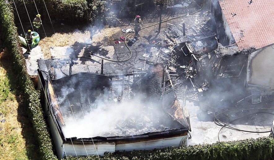 Firefighters work at the scene of a structure fire in West Valley City, Utah, on Thursday, Aug. 9, 2018. A West Valley City code enforcement officer was fatally shot nearby. (Ravell Call/The Deseret News via AP)