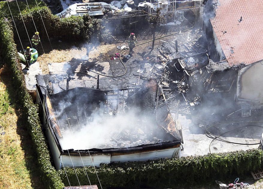 Firefighters work at the scene of a structure fire in West Valley City, Utah, on Thursday, Aug. 9, 2018. A West Valley City code enforcement officer was fatally shot nearby. (Ravell Call/The Deseret News via AP)