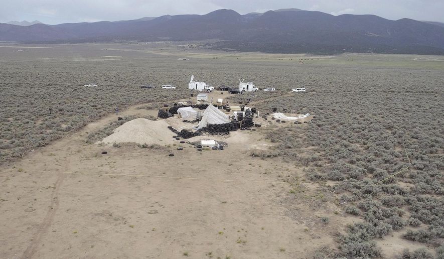 This aerial image shows a remote outpost near Amalia, N.M on Thursday, Aug. 9, 2018. Three siblings and two other adults have been charged with child abuse stemming from the alleged neglect of 11 children found living on the squalid compound. All five are being jailed without bail in New Mexico. (Karl Brennan/DroneBase via AP)