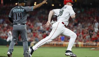 Cincinnati Reds&#39; Anthony DeSclafani (28) runs home to score on a bunt single by Billy Hamilton off Arizona Diamondbacks starting pitcher Clay Buchholz and a throwing error by Buchholz during the seventh inning of a baseball game, Friday, Aug. 10, 2018, in Cincinnati. (AP Photo/John Minchillo)