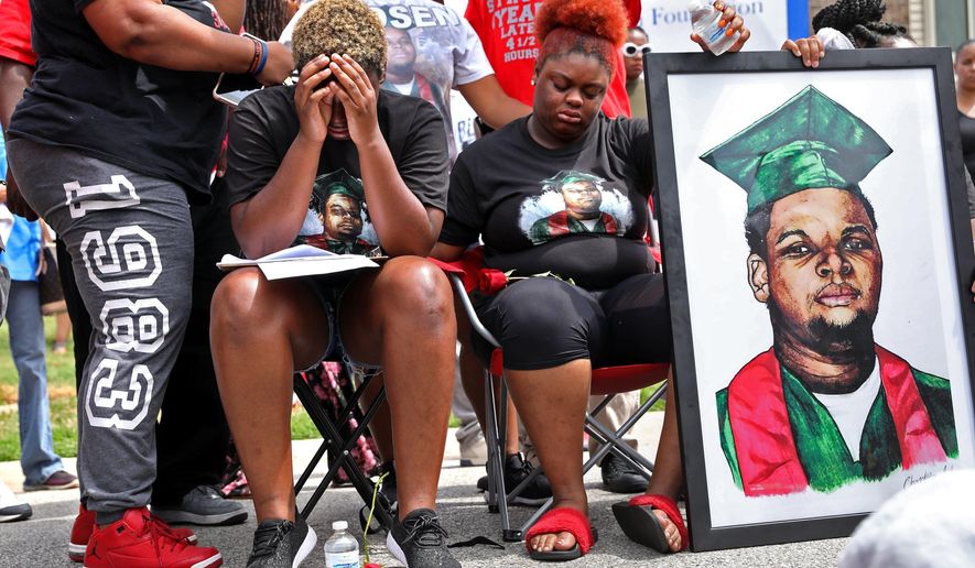 Trinetta, center left, 19, and Triniya Brown become emotional during a memorial service for their brother, Michael Brown, on Thursday, Aug. 9, 2018, in the Canfield Green apartment complex in Ferguson, Mo., where Brown was shot and killed by former Ferguson police officer Darren Wilson four years ago. (Cristina M. Fletes/St. Louis Post-Dispatch via AP)