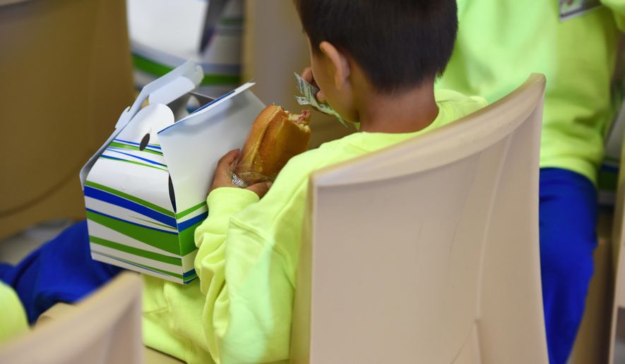 In this Thursday, Aug. 9, 2018, photo, provided by U.S. Immigration and Customs Enforcement, a boy eats at South Texas Family Residential Center in Dilley, Texas. Currently housing 1,520 mothers and their children, about 10 percent are families who were temporarily separated and then reunited under a “zero tolerance policy” that has since been reversed. (Charles Reed/U.S. Immigration and Customs Enforcement via AP)