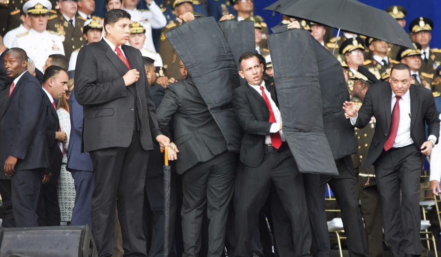 Security personnel surrounded Venezuelan President Nicolas Maduro when an explosive-laden drone disrupted a military parade in Caracas last week. Various groups purporting to represent former and active members of Venezuela&#39;s armed forces have claimed responsibility, and some opposition leaders say the assassination attempt was a hoax engineered by the regime to justify an even greater crackdown on dissent. (Associated Press/File)