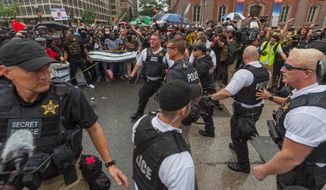D.C. Metropolitan Police and Secret Service officers were forced back by counterprotesters outside of a security barrier on 17th street while attempting to escort attendees of the &quot;Unite the Right 2&quot; rally from Lafayette Park in Northwest. (Associated Press)