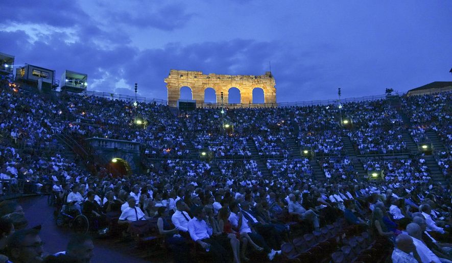 Spectators watch Rossini’s ‘’Barbiere di Siviglia’’ at the Verona Arena, in Verona, Northern Italy, Saturday, Aug. 4, 2018. After the colossal Roman-era Verona Arena amphitheater lost audience and prestige, nearly closing two seasons ago under a mountain of debt, artists and public that have sustained it are putting hopes for a relaunch in 57-year-old former singer Cecilia Gasdia, in her first season as general manager. (AP Photo/Martino Masotto)