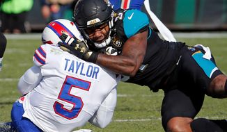 FILE - In this Jan. 7, 2018, file photo, Jacksonville Jaguars defensive end Yannick Ngakoue, right, draws a penalty by hitting Buffalo Bills quarterback Tyrod Taylor (5) with helmet-to-helmet contact in the first half of an NFL wild-card playoff football game, in Jacksonville, Fla. The Jaguars have suspended All-Pro cornerback Jalen Ramsey and defensive end Dante Fowler for violating team rules and conduct unbecoming a Jaguars football player. Fowler was involved in several fights, including one after practice with Ngakoue. (AP Photo/Stephen B. Morton, File)