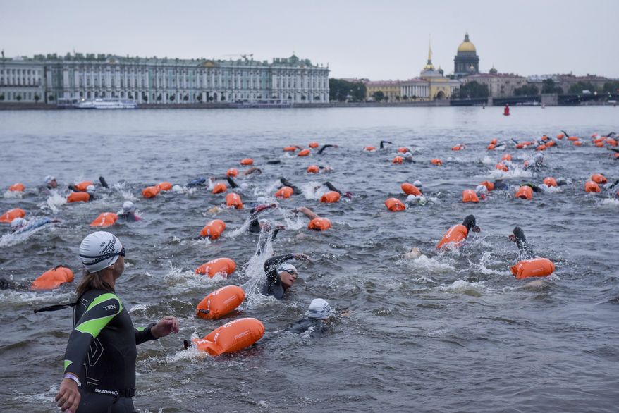 People swim after the mass start in the Neva River in St.Petersburg, Russia, Sunday, Aug. 12, 2018. More than 600 swimmers from 13 countries have swum their way through one of Russia's most scenic and historic settings, circling the St. Petersburg island that holds the Peter and Paul Fortress. (AP Photo/Alexander Belenky)