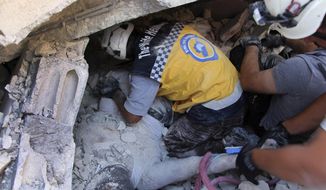 This photo provided by the Syrian Civil Defense White Helmets, which has been authenticated based on its contents and other AP reporting, shows Syrian White Helmet civil defense workers remove a body from the rubble at the scene of an explosion that brought down a five-story building, in the village of Sarmada, near the Turkish border, north Syria, Sunday, Aug. 12, 2018. Syrian opposition activists say the explosion killed several people and wounded many others. The cause of the blast wasn&#39;t immediately known. (Syrian Civil Defense White Helmets via AP)