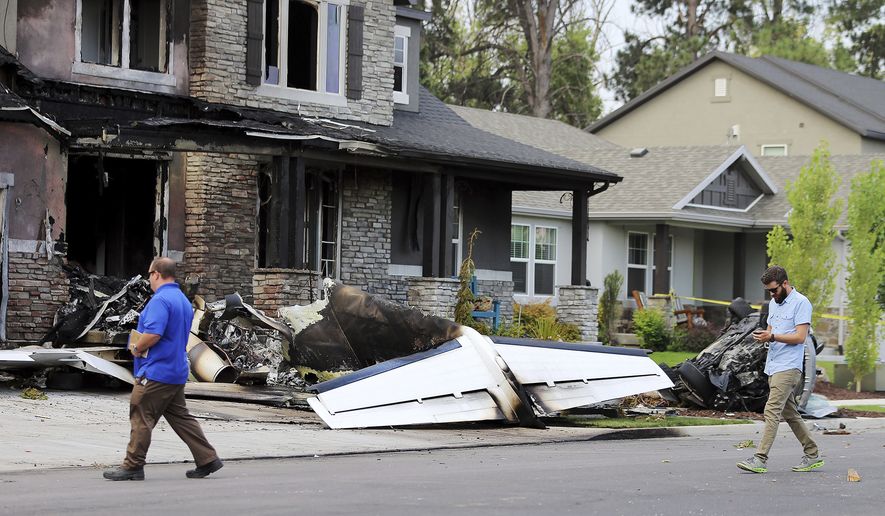 Federal Aviation Administration officials investigate the scene of a plane crash in Payson, Utah on Monday, Aug. 13, 2018. Authorities say the small plane has crashed into a house in Utah, killing the pilot. (Scott G Winterton/The Deseret News via AP)