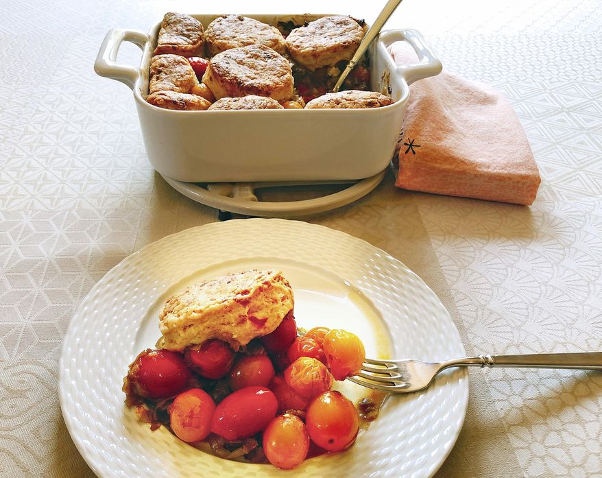 This Aug. 12, 2018 photo shows cherry tomato cobbler with pimento cheese biscuits from a recipe by Elizabeth Karmel in Amagansett, N.Y. To keep the cobbler simple and showcases fresh vine-ripened local tomatoes, the recipe features just two basic ingredients, leeks and tomatoes. (Elizabeth Karmel via AP)