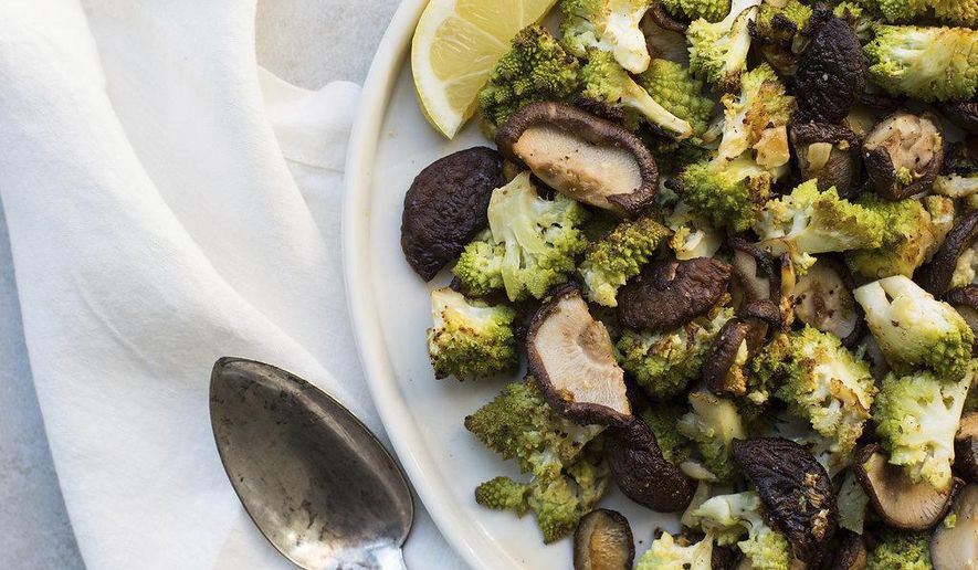 This February 2017 photo shows roasted broccoflower and shiitake mushrooms with rosemary and garlic in New York. This dish is from a recipe by Katie Workman. (Sarah Crowder via AP)