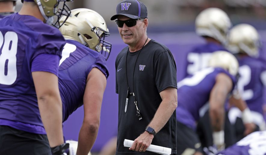 File- This Aug. 3, 2018, file photo shows Washington head coach Chris Petersen walking on the field during a team football practice in Seattle. Petersen’s Huskies are the preseason favorites to win the Pac-12 with their roster full of NFL-caliber talent, but the entire league is looking for an improved season after going 1-8 in bowl games last winter. (AP Photo/Elaine Thompson, File)