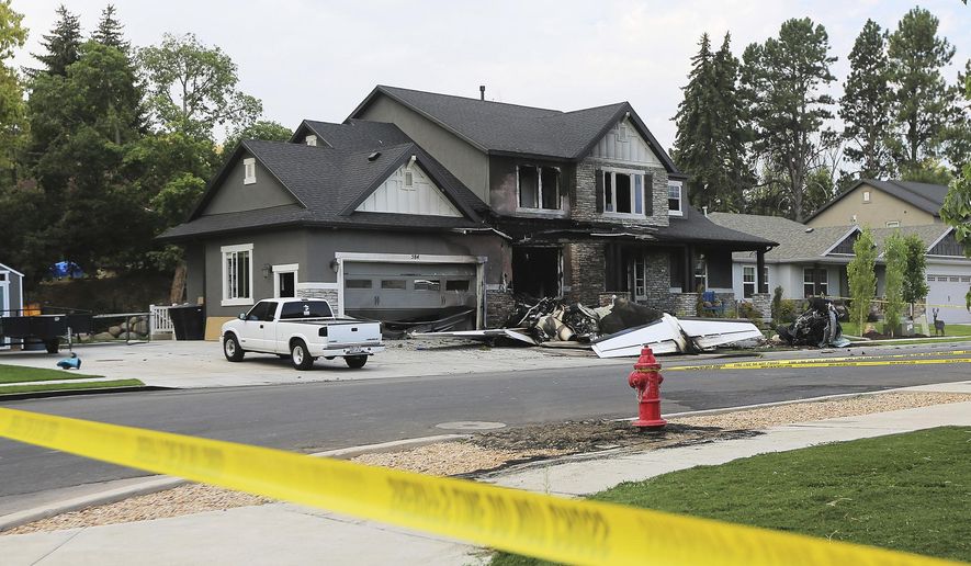 The scene of a plane crash is blocked off as Federal Aviation Administration officials investigate the area in Payson, Utah on Monday, Aug. 13, 2018. Authorities say the small plane has crashed into a house in Utah, killing the pilot. (Scott G Winterton /The Deseret News via AP)