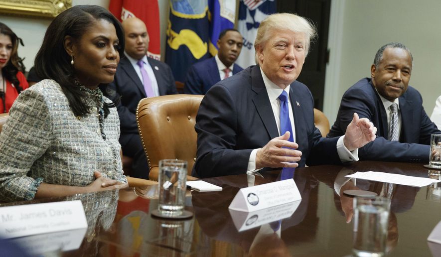 FILE - In this Feb. 1, 2017, file photo, President Donald Trump, center, is flanked by White House staffer Omarosa Manigault Newman, left, and  then-Housing and Urban Development Secretary-designate Ben Carson as he speaks during a meeting on African American History Month in the Roosevelt Room of the White House in Washington. Manigault Newman, who was fired in December, released a new book &amp;quot;Unhinged,&amp;quot; about her time in the White House. (AP Photo/Evan Vucci, File)