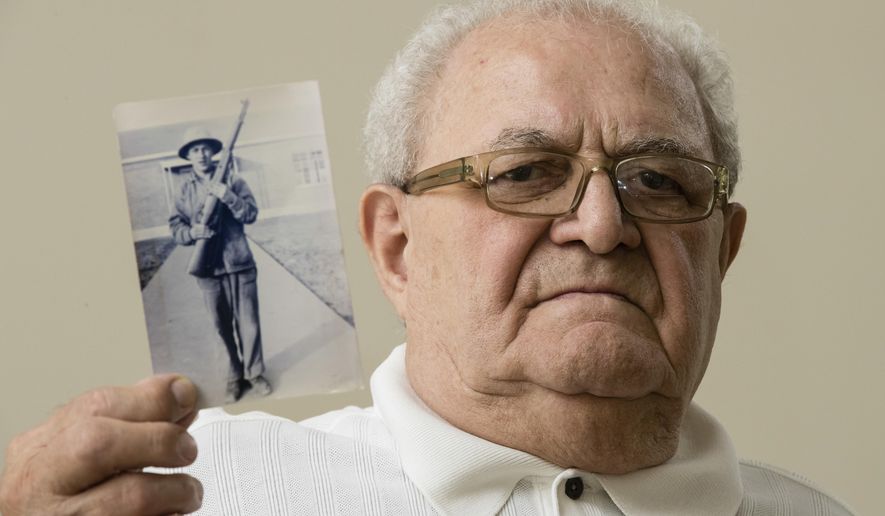 In this July 31, 2018, photo, Dominic Ragucci poses for a portrait in Philadelphia with a photo of his brother, Emil, who was killed in action during World War II. Nearly 70 years after Emil's death in the South Pacific Battle of Tarawa, his remains are scheduled to return home to Philadelphia on Monday, Aug. 13, 2018. (AP Photo/Matt Rourke)